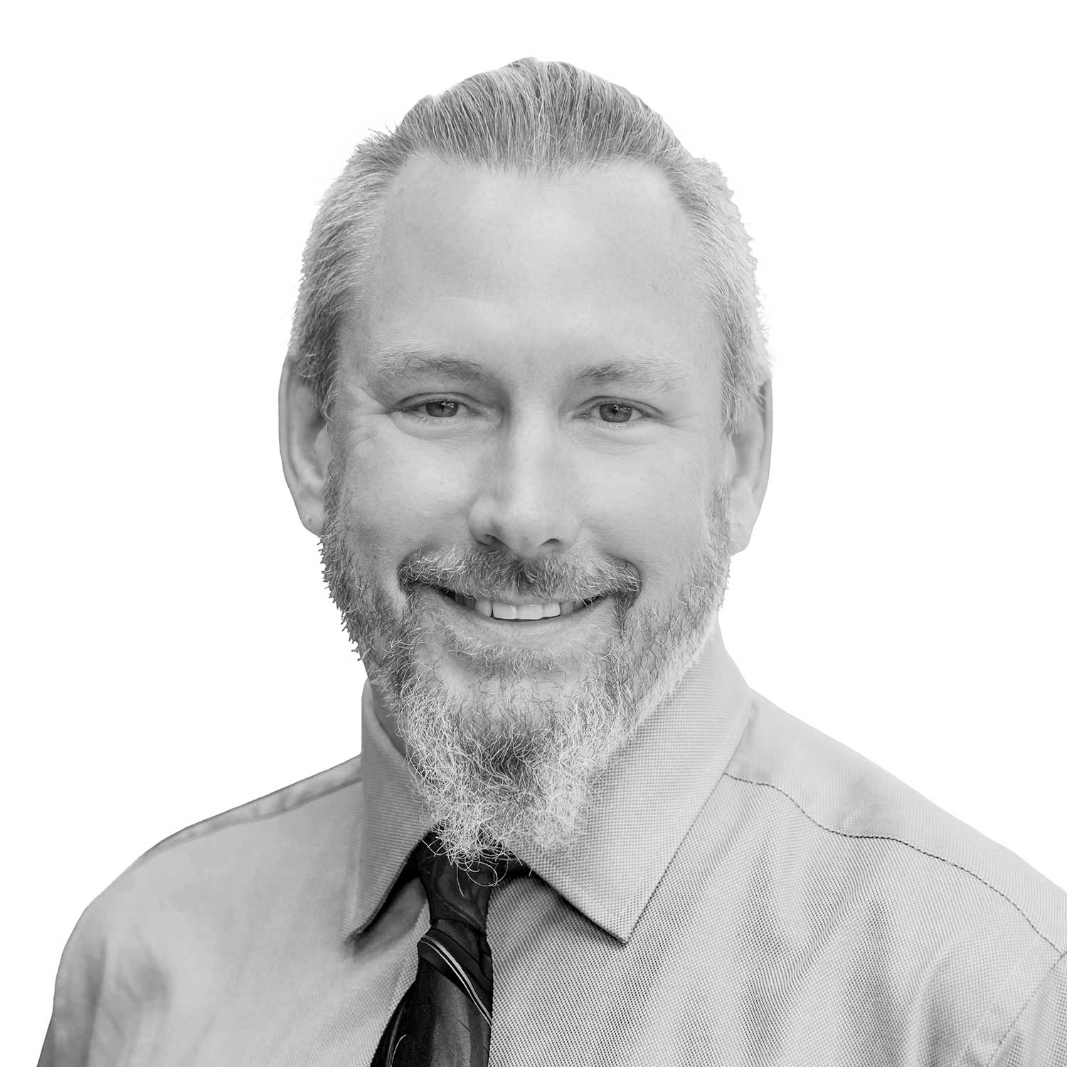 Black and white professional headshot of a smiling man with a graying beard, wearing a shirt and tie.