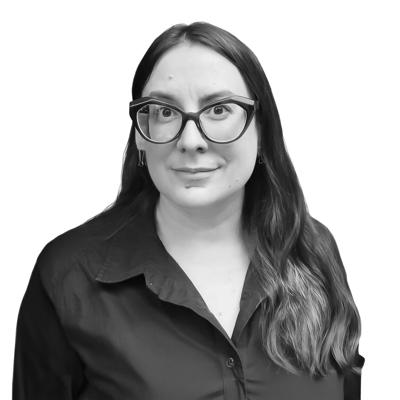 Head-and-shoulders portrait of a woman with long dark hair, thick rectangular glasses, and a black shirt, smiling at the camera on a white background.